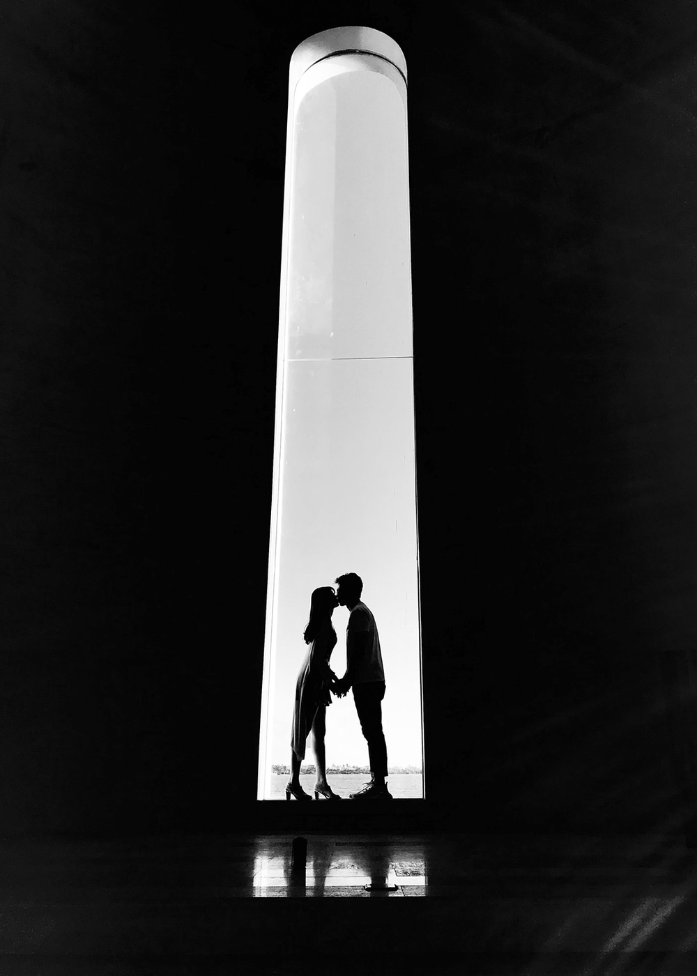 a couple kissing under an arch