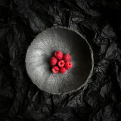 raspberries in a black bowl
