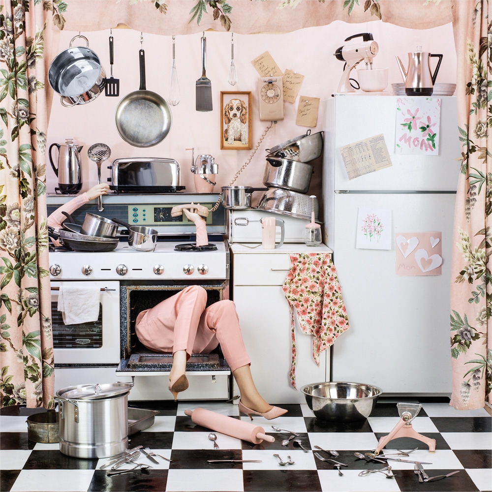 Pink decorative room with a woman stuck in a stove. Only her legs can be seen.